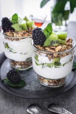Kivili parfe, böğürtlen, granola ve yoğurt. Sağlıklı ve lezzetli bir tatlı.