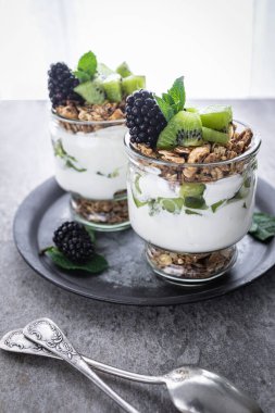 Kivili parfe, böğürtlen, granola ve yoğurt. Sağlıklı ve lezzetli bir tatlı.