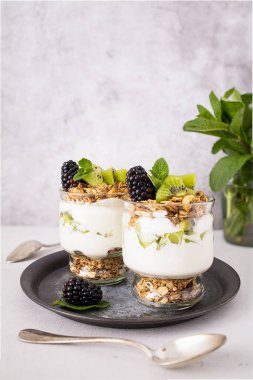 Kivili parfe, böğürtlen, granola ve yoğurt. Sağlıklı ve lezzetli bir tatlı.
