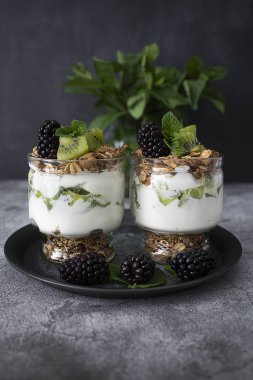 Kivili parfe, böğürtlen, granola ve yoğurt. Sağlıklı ve lezzetli bir tatlı.