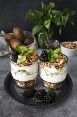 Kivili parfe, böğürtlen, granola ve yoğurt. Sağlıklı ve lezzetli bir tatlı.