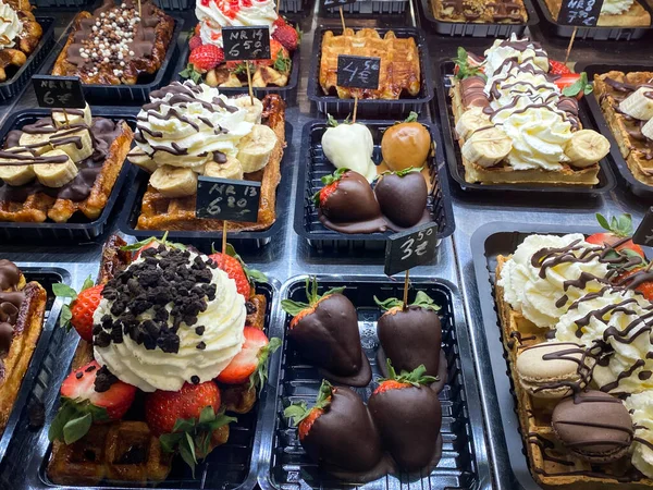 Çok çeşitli waffle 'ları olan bir Belçika pastanesinin vitrininde. Belçika tatlıları.