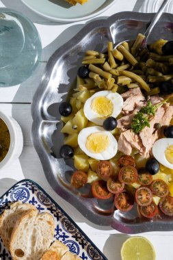 Ton balıklı patates salatası, haşlanmış yumurta, yeşil fasulye, vişneli domates ve salata soslu zeytin.