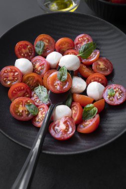 Cherry tomato salad with mozzarella cheese and fresh basil. Delicious caprese salad
