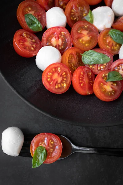 Cherry tomato salad with mozzarella cheese and fresh basil. Delicious caprese salad