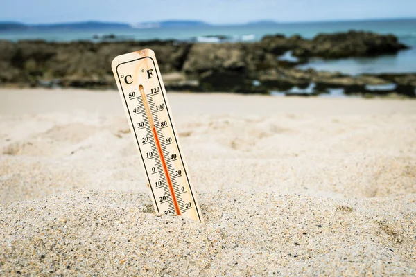 Thermometer on the beach marking high temperatures. Climate change. Global warming. Ecological problems of the planet.