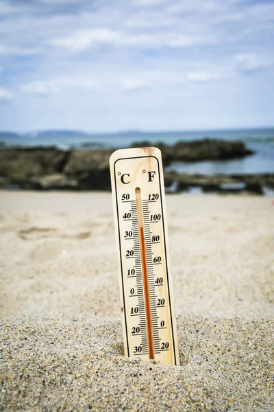Thermometer on the beach marking high temperatures. Climate change. Global warming. Ecological problems of the planet.