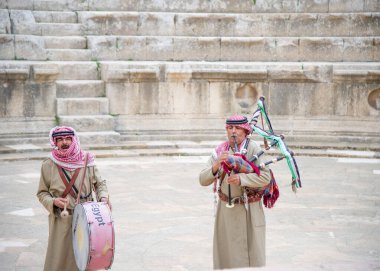 26 Aralık 2021 'de Jerash' taki Ürdünlü şarkıcılar turist çekmek için gayda çalıyorlar.