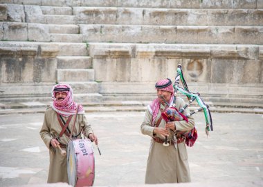 26 Aralık 2021 'de Jerash' taki Ürdünlü şarkıcılar turist çekmek için gayda çalıyorlar.