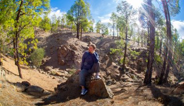 Tenerife 'deki dağlarda poz veren olgun bir kadın Teide yanardağı yakınındaki güneşte