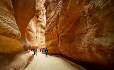 Ürdün 'de Petra' yı ziyaret eden turistler 25 Şubat 2020 'de yürür veya Bedevi arabalarından yardım alırlar