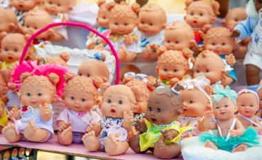 Beautiful baby dolls colorfully dressed at a shop on the street dressed in different clothes