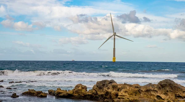 February 03 2022.A giant eolian wind turbine producing green energy in the Atlantic Ocean near the western coast of Gran Canaria.In the background are blue sky.