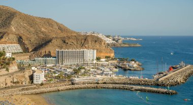 2 Şubat 2022 'de Porto Riko köyü tatil köyü ve Gran Canaria İspanya plajında sarı kum ve volkanik dağlarla panoramik manzara