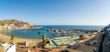 2 Şubat 2022 'de Porto Riko köyü tatil köyü ve Gran Canaria İspanya plajında sarı kum ve volkanik dağlarla panoramik manzara