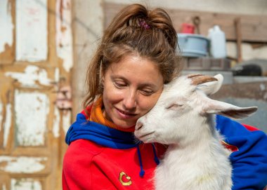 17 Aralık 2020 'de yetişkin bir kadın keçinin kafasına dokunarak bir keçiye sıkıca sarılıyor.