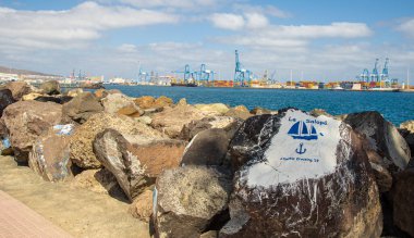 Paintings on stones in the harbour of Las Palmas de Gran Canary Spain, in the background you can see the industrial harbour