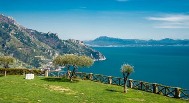 Landscape of colourful flowers and palm trees on the Amalfi coast of Ravello Italy with bright sun and blue sky