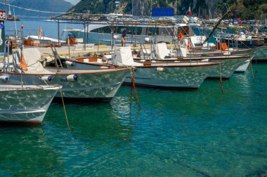 Capri İtalya 'da berrak bir göl suyuna demirlemiş turistleri bekleyen tekneler var.