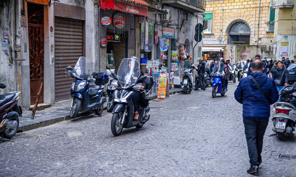 04 апреля 2022 - Неаполь Италия - Толпа улиц одним утром с большим количеством скутеров и людей, идущих на работу мимо старых красочных зданий