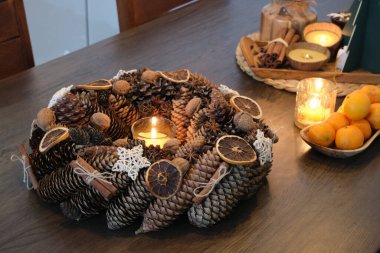 Balmumu mumu ile süslenmiş ev yapımı Advent çelengi.