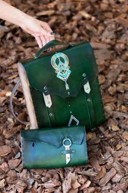 Kadının elinde yeşil deri ve ahşaptan yapılmış bir çanta var.