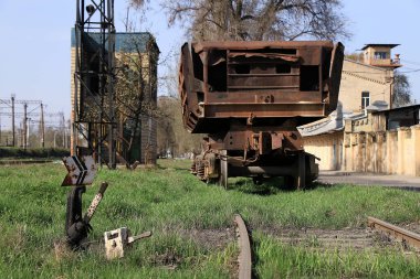 Raylarda paslı yük vagonu var.