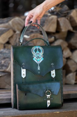 Kadının elinde yeşil deri ve ahşaptan yapılmış bir çanta var.