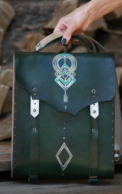 Kadının elinde yeşil deri ve ahşaptan yapılmış bir çanta var.