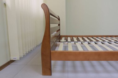 Yatak olmayan odada çift katlı ahşap bir yatak çerçevesi.