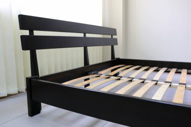 Koyu ahşap çift yatak ve sert sırt.