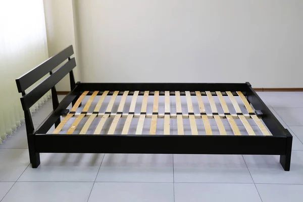 Koyu ahşap çift yatak ve sert sırt.