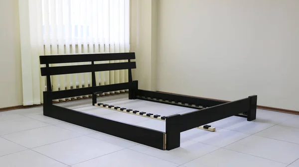 Koyu ahşap çift yatak ve sert sırt.