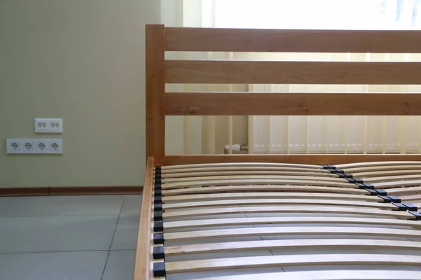 frame of a simple lacquered bed made of wood with slats without mattress