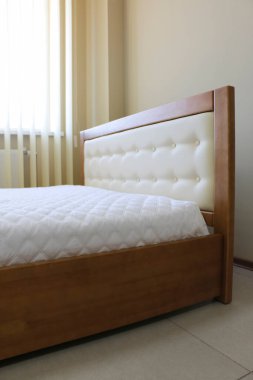 Yumuşak beyaz deri döşemeli yatak başlığı, ahşap kaplamalı çift katlı yatak