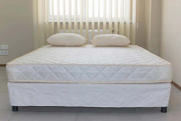 double bed frame with soft mattress cover and pillows