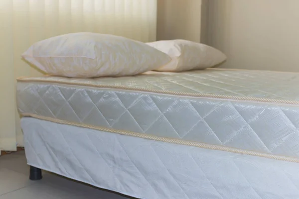 double bed frame with soft mattress cover and pillows, close-up
