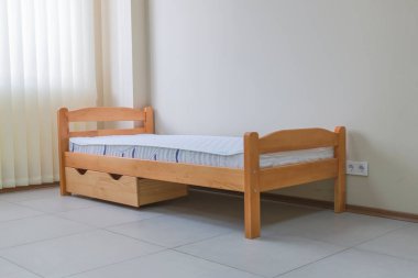 Çocukların tek tahta yatağı, şilte ve çekmeceleri.