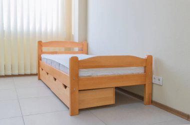 Yatağı ve çekmeceleri olan tek bir tahta yatak.