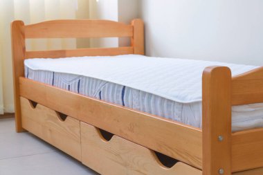 Yatağı ve çekmeceleri olan tek bir tahta yatak.