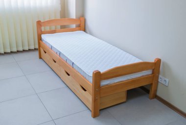 Çocukların tek tahta yatağı, şilte ve çekmeceleri.