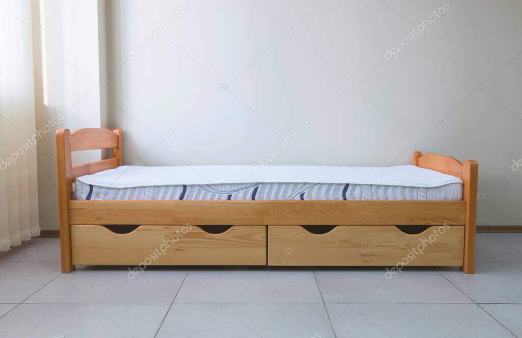 single wooden bed with mattress and drawers