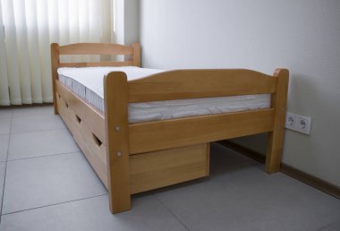 Yatağı ve çekmeceleri olan tek bir tahta yatak.