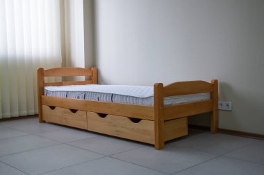 Yatağı ve çekmeceleri olan tek bir tahta yatak.