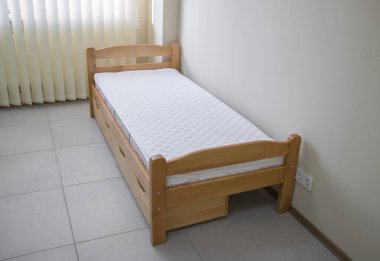 Yatağı ve çekmeceleri olan tek bir tahta yatak.