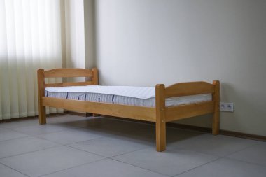 Yatağı ve çekmecesi olan tek bir ahşap yatak.