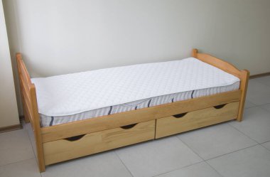 Yatağı ve çekmeceleri olan tek bir tahta yatak.