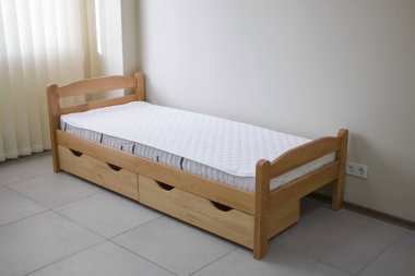 Yatağı ve çekmeceleri olan tek bir tahta yatak.