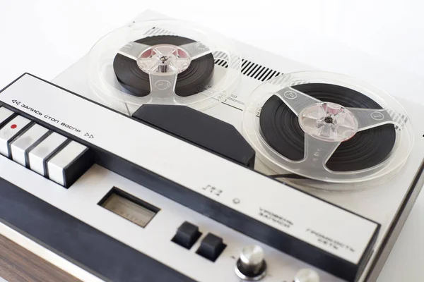 old-style reel-to-reel tape recorder, with inscriptions (record, stop, play, volume, network, level,) selective focus, close-up on a white background