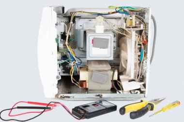 Parçalanmış mikrodalga fırın, izole bir arka planda magnetron onarımı.